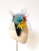 black leather padded halo crown headband, with coral, yellow, green and blue spikey feather flowers and black widow veiling