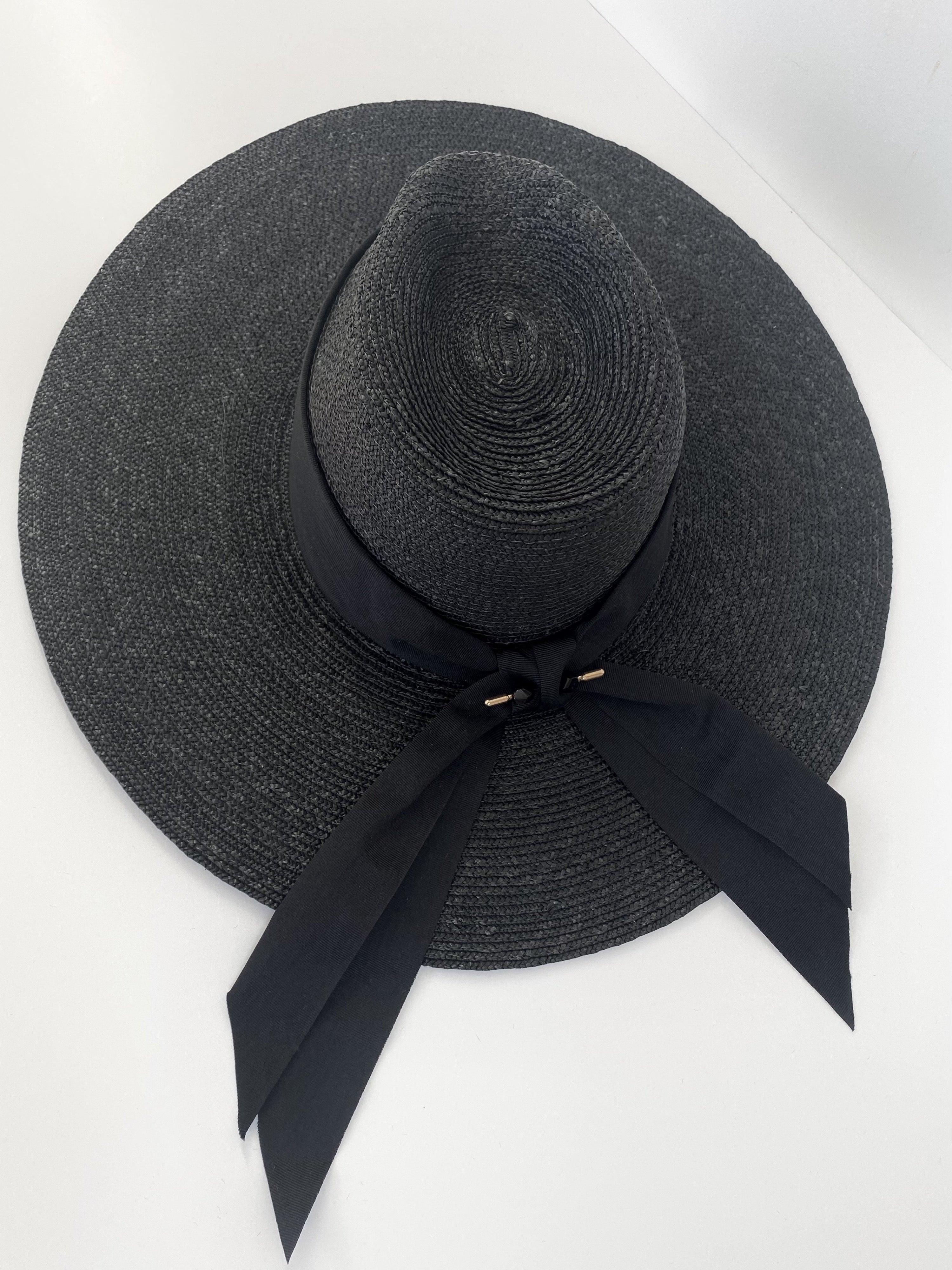large black wide brimmed sun hat with large ribbon at back. Moira Schitts creek