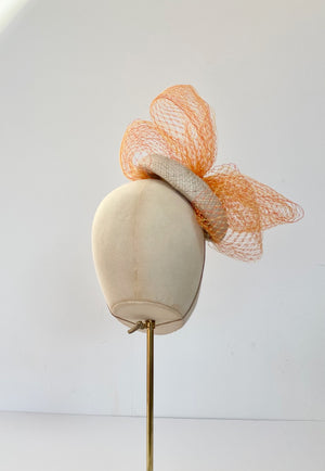 natural button cocktail hat with orange and yellow veiling bow, ideal for Royal Ascot, wedding hat